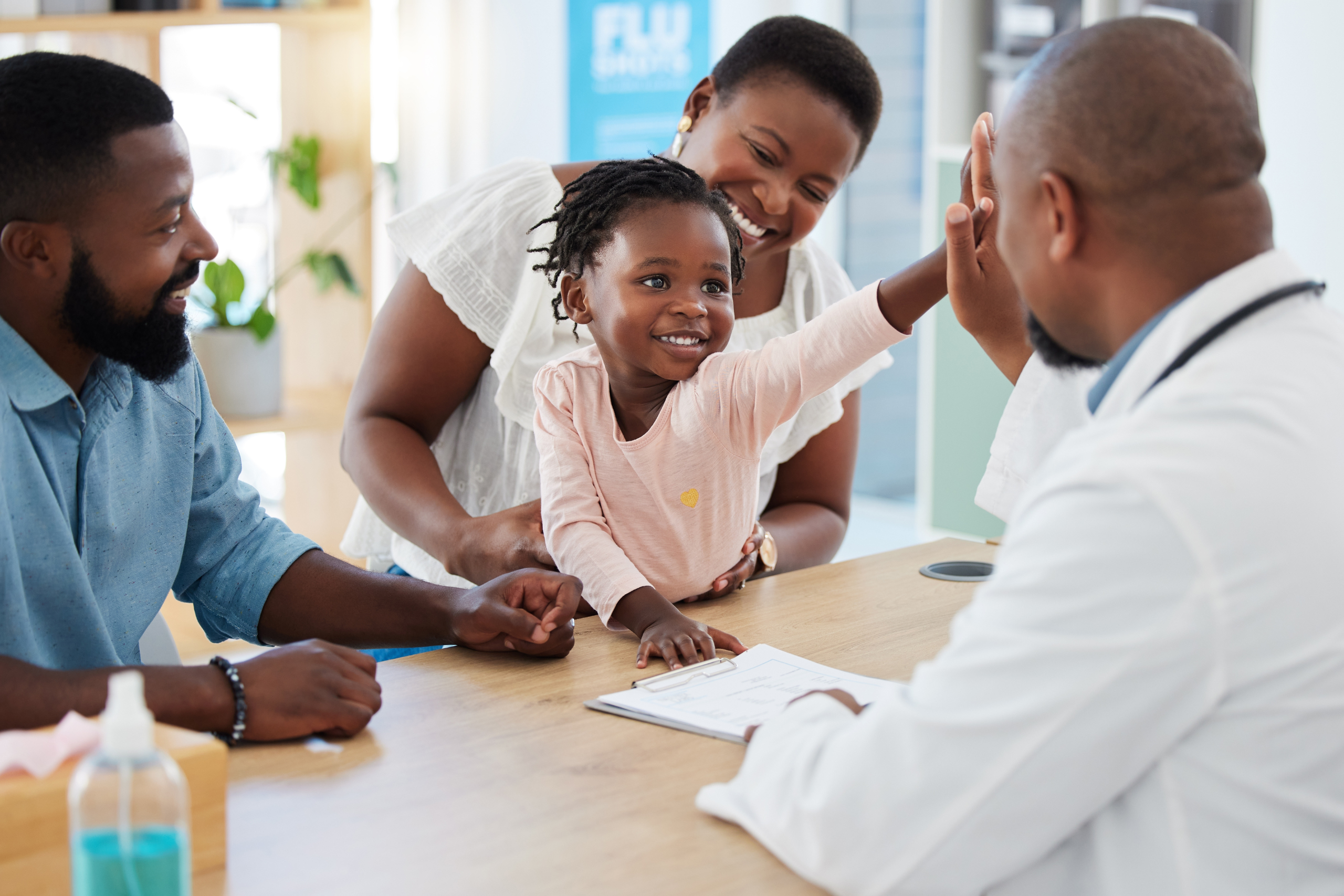 A young girl at the doctor with her mother and father, representing the benefits of managed care organizations